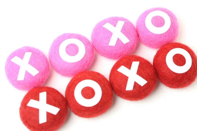May include: Pink and red felt balls with white letters spelling out "XOXO" on each ball.