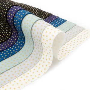 May include: A stack of felt fabric sheets with a gold star pattern. The sheets are in various shades of blue, gray, and white.