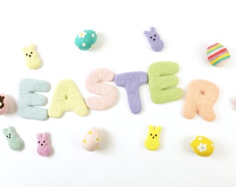 May include: Felt Easter decorations in pastel colors, including the word "Easter" spelled out in letters, bunnies, and eggs.