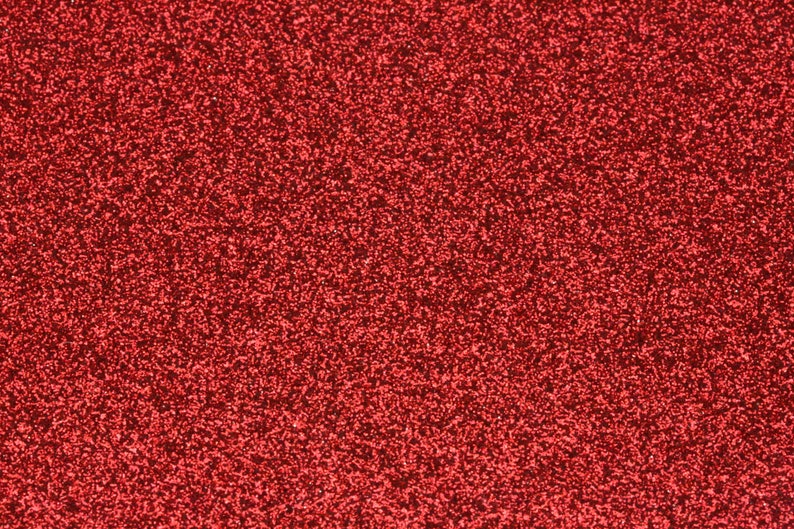 May include: A close-up of a red glitter background. The glitter is very fine and creates a sparkling effect.