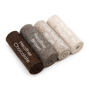 Puede incluir: Cuatro rollos de tela de fieltro en diferentes tonos de marr&oacute;n y beige. Los rollos est&aacute;n etiquetados como "Heather Chocolate", "Heather Brown", "Dark Heather Beige" y "Heather Beige".