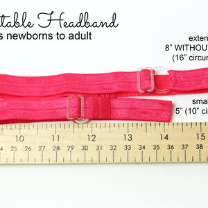 May include: Pink adjustable headband with clear plastic buckles. The headband measures 5 inches at its smallest size and extends to 8 inches without stretching. A ruler is shown for reference.