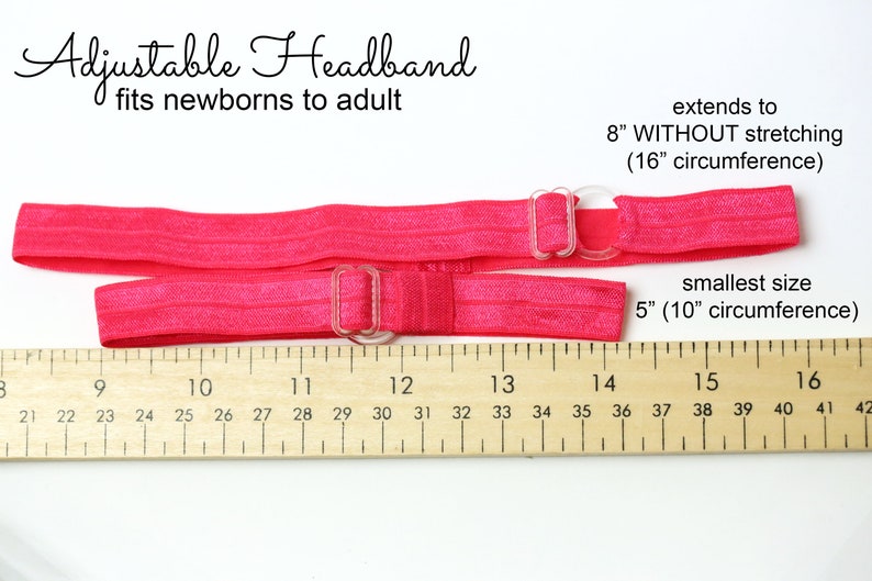 May include: Pink adjustable headband with clear plastic buckles. The headband measures 5 inches at its smallest size and extends to 8 inches without stretching. A ruler is shown for reference.