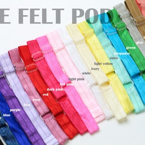 May include: A variety of colors of felt hair ties with a metal clasp. The colors include black, navy, blue, purple, lilac, rose, red, dark pink, hot pink, light pink, white, ivory, light yellow, aqua, turquoise, green, gray, latte, coral, and orange.