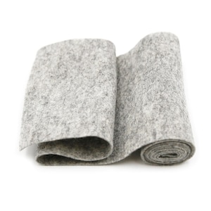 May include: A roll of grey felt fabric. The fabric is rolled up and the end is visible.