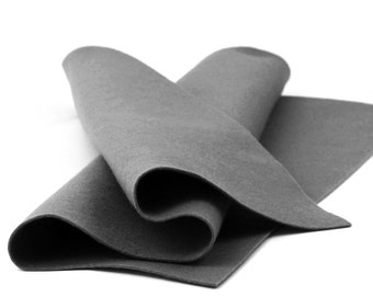 Könnte beinhalten: Ein gefaltetes Stück dunkelgrauer Filzstoff. Der Stoff ist glatt und hat eine weiche Textur.