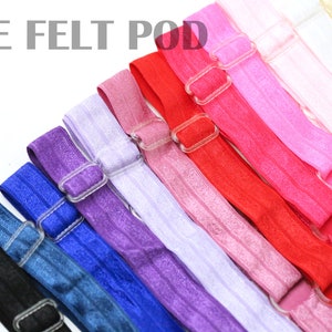 May include: A set of 10 colorful elastic hair ties with adjustable plastic buckles. The hair ties are arranged in a rainbow pattern, starting with black and ending with yellow.