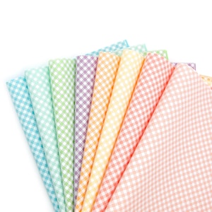 May include: A set of eight fabric squares in a rainbow of colors, each with a white gingham pattern. The squares are arranged in a fan shape, with the lightest color at the top and the darkest color at the bottom.