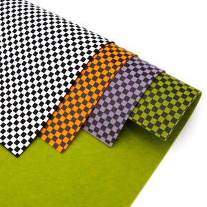 Puede incluir: Cuatro hojas de fieltro a cuadros en blanco y negro, naranja y negro, morado y negro y verde y negro.