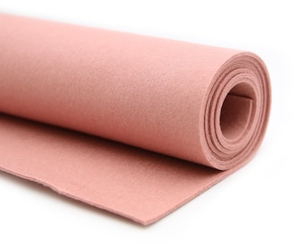 May include: A roll of light pink felt fabric. The felt is rolled up and the end of the roll is laying flat.