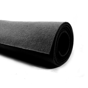 May include: A roll of black felt fabric. The fabric is rolled up tightly and has a smooth, even texture.