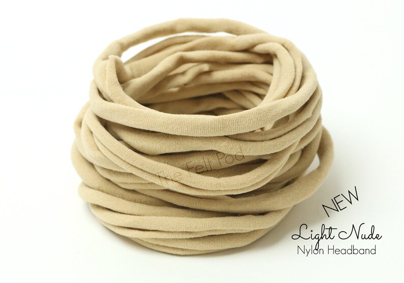 May include: A close-up of a large spool of light nude nylon headband material. The material is soft and stretchy, and it is perfect for making headbands, hair ties, and other accessories. NEW Light Nude Nylon Headband.