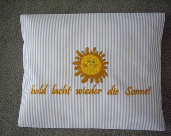 Kirschkernkissen-Wärmekissen-Körnerkissen bestickt mit dem Schriftzug "Bald lacht wieder die Sonne!" und einer kindlichen Sonne