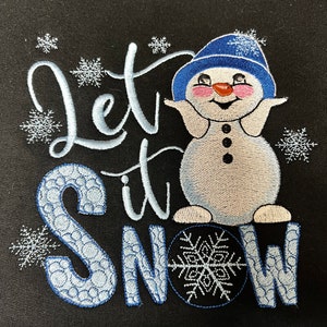 May include: Embroidered design on a black fabric featuring a snowman with a blue hat and the text "Let it Snow".