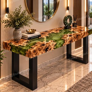 Puede incluir: Una mesa consola rectangular con un tablero de madera de raíz de borde natural y una incrustación central de resina epoxi verde translúcida. La mesa se apoya sobre dos patas de metal negro en forma de U y está decorada con un jarrón, libros y una escultura.