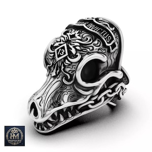May include: A silver-toned metal bead shaped like a stylized wolf head with intricate scrollwork engravings. The design features a diamond-shaped emblem with the number 13, a chain-link pattern along the jaw, and the text INVICTUS engraved on top.