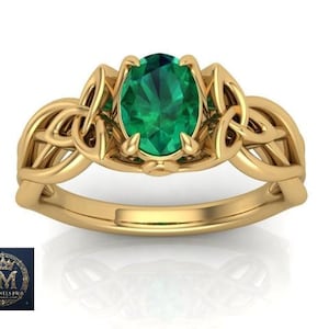 May include: A gold ring featuring a central oval-cut green gemstone held by four prongs. The band is crafted with an intricate, interwoven knotwork design that extends from the setting along the sides of the ring, creating a continuous pattern.