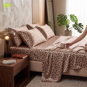 May include: A bed sheet set featuring a brown and black leopard print pattern. The set includes a fitted sheet, a flat sheet, and three matching pillowcases, all displaying a consistent animal print design across the fabric surface.