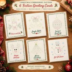 May include: Six white greeting cards featuring Christmas embroidery patterns with green leaf borders. Designs include a candle, bells, ornament, reindeer, tree, and snowman with text: Peace and Joy, Jingle Bells, Season's Greetings, Happy Holidays, Merry Christmas, Let It Snow.