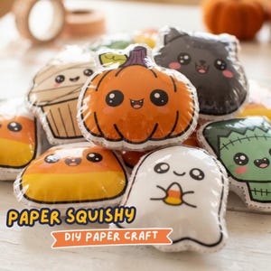 May include: A collection of Halloween-themed paper squishies featuring a pumpkin, ghost, black cat, mummy, candy corn, and Frankenstein monster. Each item has a cartoon face with large eyes. The text reads PAPER SQUISHY DIY PAPER CRAFT.