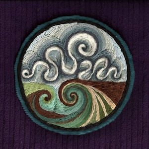 May include: A circular embroidery depicting a stylized wave with swirling blue, green, and brown threads. The wave is set against a background of white and blue clouds.