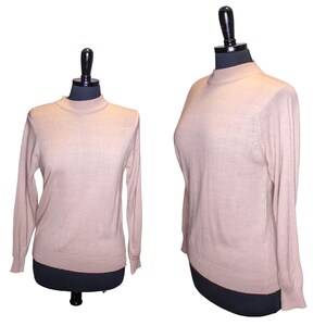 May include: A light brown long-sleeved sweater with a mock neck.