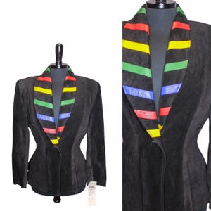 May include: A black suede jacket with a wide collar featuring colorful stripes in red, yellow, green, and blue.