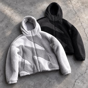 May include: Two zip-up hooded jackets made of textured fleece material. One jacket features a light gray and white abstract pattern, while the other jacket is solid black. Both garments include long sleeves, a front zipper closure, and a hood.