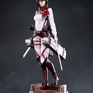 Op de afbeelding: Een 1:8 schaal, 24 cm hoog anime-stijl figuur van een personage met kort zwart haar, gekleed in een wit overhemd met lange mouwen, een rode sjaal en bruine lederen uitrusting met riemen. Het figuur houdt twee zilveren zwaarden vast op een rots.