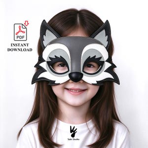 May include: A gray, white, and black raccoon mask with pointed ears and a rounded nose. The mask features cutouts for eyes and is presented as a PDF instant download. The text PDF INSTANT DOWNLOAD is visible in the upper left corner of the image.