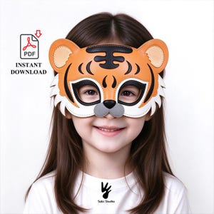 May include: A tiger mask featuring orange, black, and white details with cutouts for eyes. The mask has rounded ears, black stripes on the forehead, and a gray nose. The image includes a PDF icon with the text INSTANT DOWNLOAD and Sabi Studio.