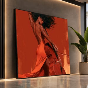 May include: A square wall art print featuring a person with dark curly hair wearing a backless orange gown while playing a cello. The artwork is rendered in shades of deep orange and red, depicting the figure from behind against a solid background.