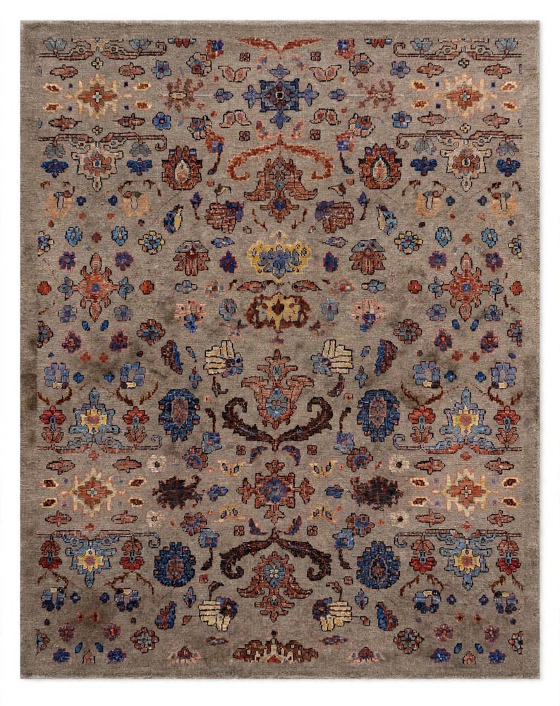 May include: A rectangular area rug featuring a taupe background with a repeating pattern of floral and geometric motifs in shades of blue, orange, yellow, and dark brown. The design is symmetrical, with intricate details distributed across the surface.