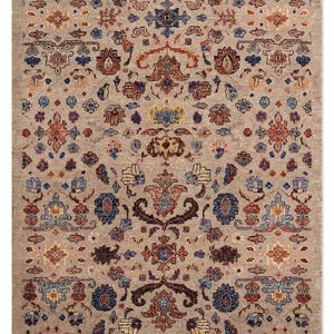 May include: A rectangular area rug featuring a light beige background with a repeating intricate pattern of floral and geometric motifs in shades of deep blue, rust orange, muted yellow, and dark brown, arranged in a symmetrical layout.
