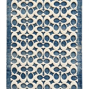 May include: A rectangular area rug featuring a deep blue background with a distressed, weathered texture. The surface is adorned with a repeating, raised white pattern consisting of interlocking C-shaped motifs arranged in a grid-like formation.