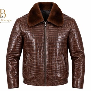 Puede incluir: Una chaqueta marrón con un patrón texturizado de piel de cocodrilo, con un cuello de piel sintética marrón oscuro y una cremallera central plateada. La prenda incluye dos bolsillos laterales y un dobladillo acanalado. Logo Luxelite Boutique.