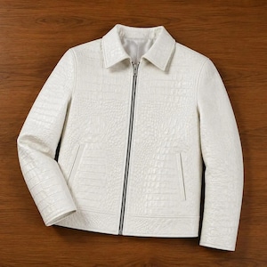 May include: A white jacket featuring a textured crocodile skin pattern throughout the exterior. The garment includes a classic collar, long sleeves, a central silver-toned metal zip closure, and two vertical slit pockets on the front panels.