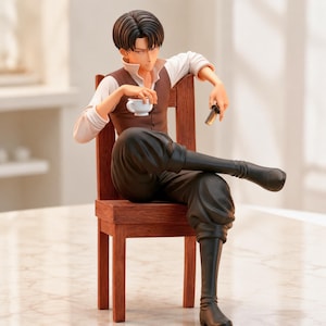 Könnte beinhalten: Eine Anime-Sammelfigur mit dunklem Haar, bekleidet mit einem weißen Hemd, einer braunen Weste und einer schwarzen Hose, die auf einem Holzstuhl sitzt. Die Figur hält eine kleine weiße Teetasse in der einen und einen kleinen schwarzen Gegenstand in der anderen Hand.