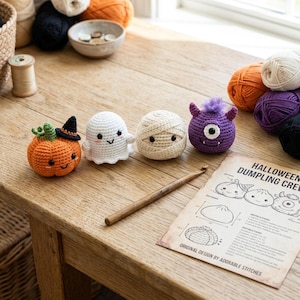 May include: Four small crocheted Halloween figures including an orange pumpkin with a black hat, a white ghost, a beige mummy, and a purple one-eyed monster. A wooden crochet hook and a printed instruction sheet titled Halloween Dumpling Crew.