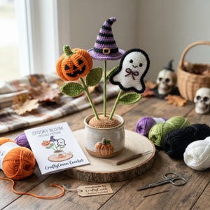 May include: A crochet Spooky Bloom set featuring a jack-o'-lantern, a purple and black striped witch hat, and a white ghost with a brown bow, all planted in a ceramic pot with a pumpkin relief. Includes a pattern booklet labelled Spooky Bloom.