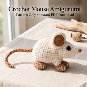 May include: A crochet mouse amigurumi featuring a cream-colored body, brown ears, brown feet, and a long brown tail. The mouse has black eyes and a small brown nose. The text reads: Crochet Mouse Amigurumi Pattern Only • Instant PDF Download.