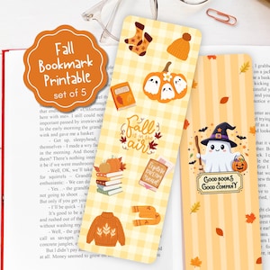 May include: Two rectangular bookmarks featuring autumn themes. One has a yellow gingham pattern with illustrations of socks, a pumpkin with ghosts, books, a sweater, and the text Fall is in the air. The other has orange stripes, a ghost wearing a witch hat, and the text Good Books & Good Company.