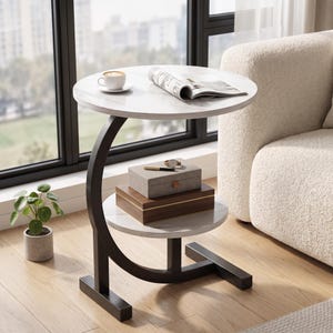 May include: A C-shaped side table with a white faux marble top and a lower shelf, supported by a black metal frame. The table holds a white coffee cup, an open magazine, a gray storage box, a wooden box, a pen, and a wristwatch.