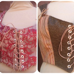 Pode incluir: Dois estilos diferentes de corpetes com tiras e cadarços de couro castanho. Um corpete é vermelho e castanho com um padrão floral, o outro é castanho com um padrão listrado.