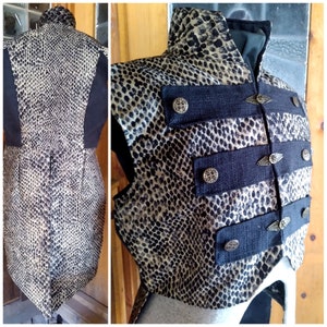 Peut inclure: Un gilet sans manches noir et or avec un motif peau de serpent et une bordure en tissu noir. Le gilet a un col montant et des boutons décoratifs.