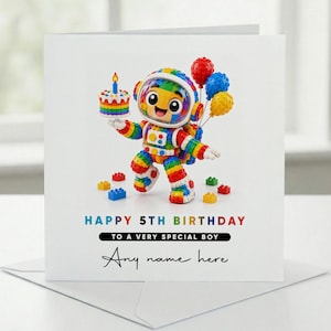 May include: A square greeting card featuring a colorful, block-built astronaut character holding a rainbow-layered birthday cake with a single candle. The text reads: HAPPY 5TH BIRTHDAY TO A VERY SPECIAL BOY, followed by the placeholder text Any name here.