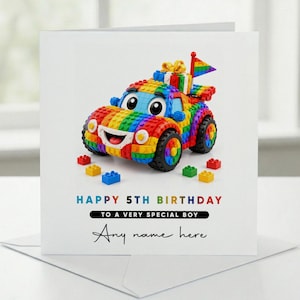 Könnte beinhalten: Eine quadratische Grußkarte mit einem bunten Spielzeugauto aus Bausteinen. Das Auto hat ein Regenbogenmuster, ein lächelndes Gesicht und eine kleine Regenbogenflagge. Text: HAPPY 5TH BIRTHDAY TO A VERY SPECIAL BOY. Any name here.
