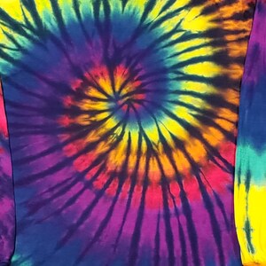 Peut inclure: Un sweat &agrave; capuche tie-dye &agrave; manches longues avec un motif en spirale dans des tons de jaune, orange, rouge, violet, bleu, vert et noir.