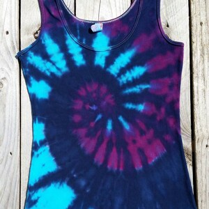 Pu&ograve; includere: Un top a canotta tie-dye con un motivo a spirale in tonalit&agrave; di blu, viola e nero.