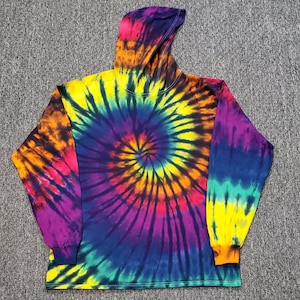 Peut inclure: Un sweat &agrave; capuche tie-dye &agrave; manches longues avec un motif tourbillonnant de violet, jaune, orange et bleu.